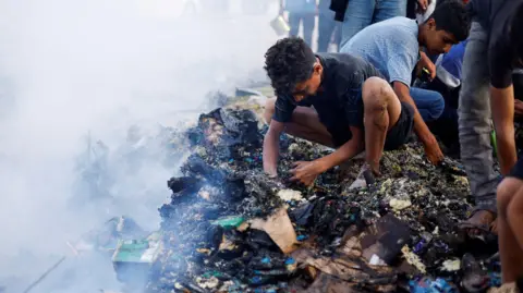 Reuters Palestinians search through the rubble of the destroyed camp