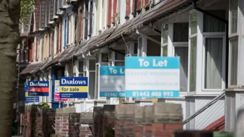 Getty Images A series of houses for sale and rent with estate agent signs in anonymous street