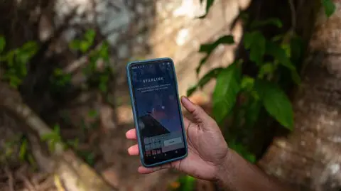 A person seen connecting a Starlink terminal to access satellite internet service 