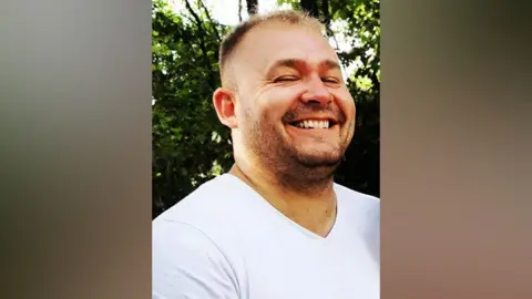 Norfolk Police Marcin Zablotny is smiling wearing a white shirt.