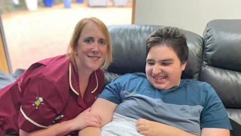 Derian House Suzanne Ward posing with a smiling boy at the hospice