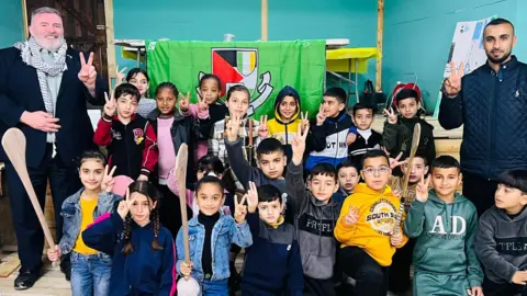 A group of young children from GAA Palestine pose alongside two adults