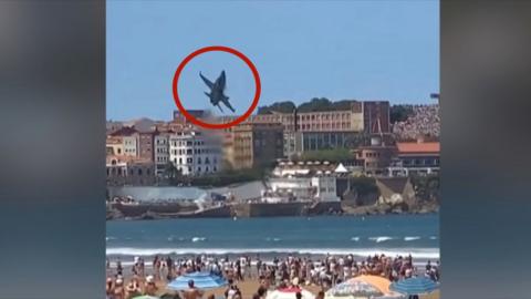 Red circle around plane flying over packed beach