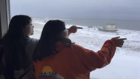 Kate Stephens/BBC Children at Churchill School look out over the Hudson Bay and spot a polar bear being moved