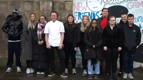 Aisling Lynch The Citadel group - a mixed group of ten young people who are training for the big fundraiser pose outside their building - adorned with graffiti designs - with chef Tom Kitchin
