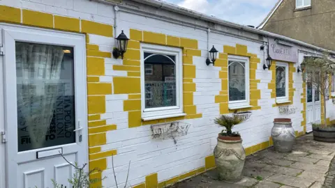 Entrance to restaurant with yellow bricks and white front