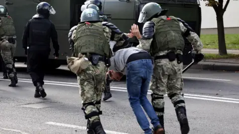 Getty Images Οι αξιωματικοί επιβολής του νόμου κρατούν έναν άνδρα κατά τη διάρκεια συγκέντρωσης διαμαρτυρίας για τα αποτελέσματα των προεδρικών εκλογών στο Μινσκ στις 13 Σεπτεμβρίου 2020