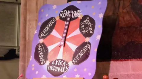 Clash of the Choirs A purple square clap-o meter showing the words extraordinary, astonishing, never to be forgotten, sparkling, memorable, and remarkable.