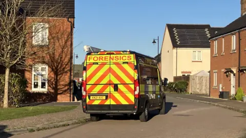 A forensics van on a road on a sunny day