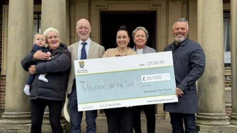 Morecambe Town Councillors Margaret Pattison, Paul Hart, Monika Stenneken and Lee Bradbury present a cheque for £16,000 to support Vintage By The Sea to Festival Director Lauren Zawadzki (centre)