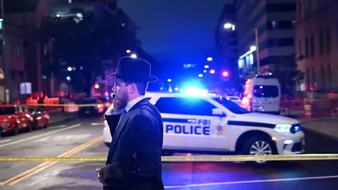 A man stands a t police cordon outside the Capital Jewish Museum 