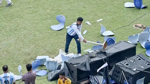 A fan attacks part of the event furniture at the stadium