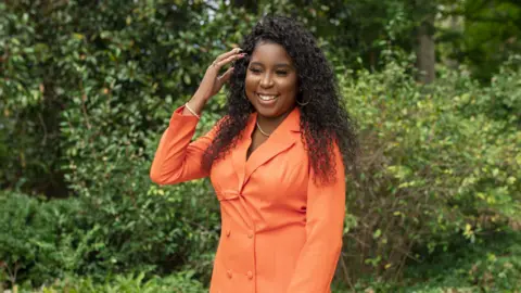 Brittany Harris-Nelson Brittany Harris-Nelson wears a bright orange coat