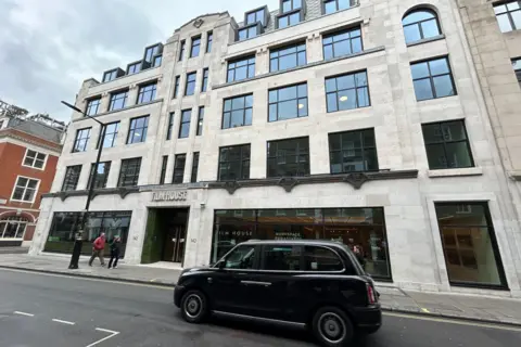 BBC/Harry Low Exterior of office building WITH black cab outside beside Film House sign