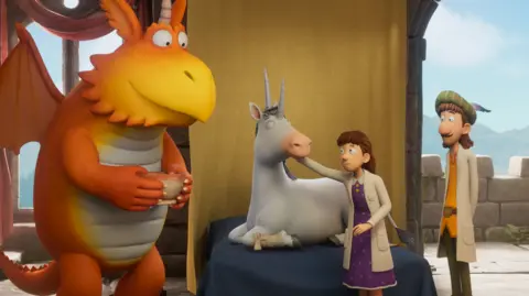 A screenshot from the CGI cartoon - more specifically, one of the episodes Ridley worked on. A unicorn with two horns, who has a bandage wrapped around one of his legs, is being tended to by two human doctors. They are dressed in medieval-style clothing but still wear white lab coats. Then, stood holding a bowl, is a friendly, orange dragon twice their size: Zog, the main character.