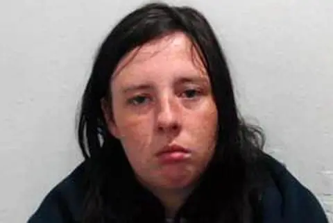Police Scotland A dark haired woman in a dark top staring at the camera