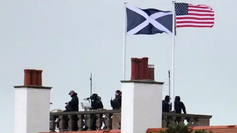 Getty Images Snipers policiais são vistos no telhado do Trump Turnberry Hotel antes da visita do presidente dos EUA, Donald Trump, em 26 de julho de 2025 em Turnberry, na Escócia.