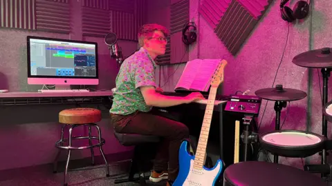 Man playing piano in a recording studio