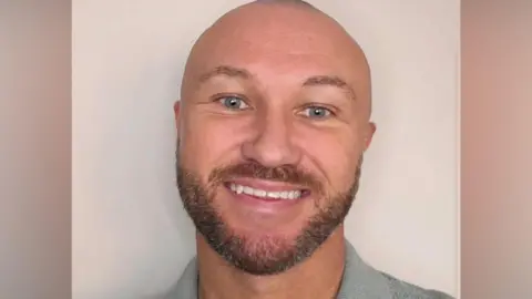 Green Party Chris Kennedy - a bald man with blue eyes and a brown beard - smiles at the camera 