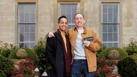 OMAZE Left to right Justin Snowdonand Paul Knight. Justin is wearing a yellow shirt and navy trenchcoat, whilst Paul is wearing a white jumper and a brown jacket.