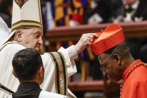 Riccardo De Luca / AFP Ignace Bessi Dogbo (R) bows his head as he receives his red biretta from Pope Francis (L) in St Peter's Basilica at the Vatican - Saturday 7 December 2024