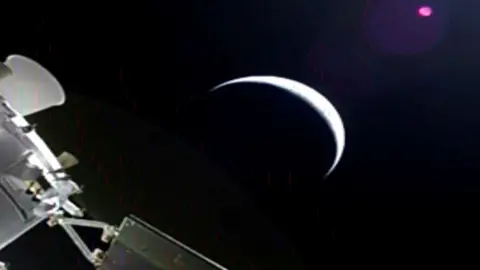 Reuters The astronauts on the Orion capsule capture a photo of a crescent earth.