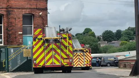 Sam Hopley Two Greater Manchester Fire and Rescue Service fire engines outside the Fieldhouse Industrial Estate after a flood.
