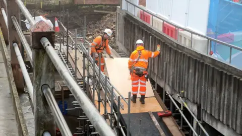 Contractors building a ramp next to the site of Chester's walls