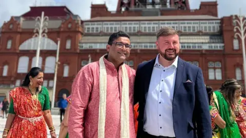 Fylde Coast Hindu Society handout Chirag Khajuria and Blackpool South MP Chris Webb in front of Blackpool Tower building