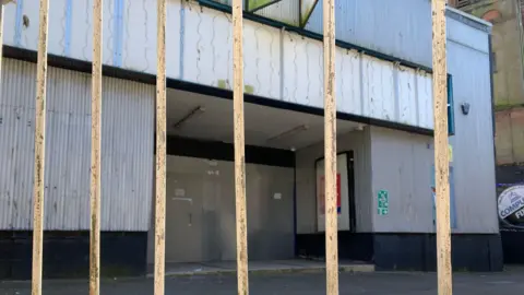 A view behind railings of the cinema facade with a corrugated frontage