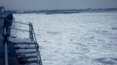 John Clague Thick layers of snow and ice stretch out a long way on the sea, past the pier. 