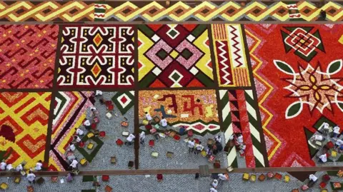 Inge Rochette and Donat Mailleux A carpet of red and yellow flowers arranged into squares containing patterns