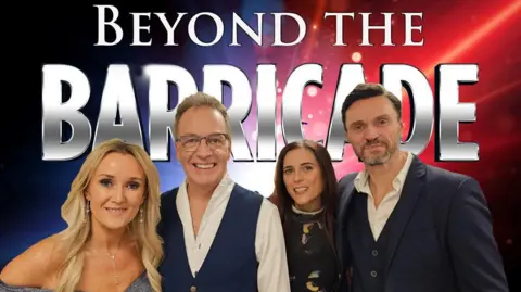 Andy Reiss Two men and two women stand in front of a sign saying "Beyond the Barricade". The left hand woman has blonde hair; the main next to her has short light hair and wears glasses. To his left is a woman with long dark hair and, on the right, is a man with short brown hair and a short grey, brown beard.