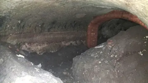 Supplied A view of an underground cave with a brick archway visible in the background.