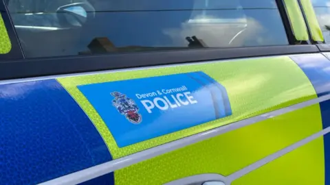 A close up of a Devon and Cornwall Police car. The logo is emblazoned across one of the doors.