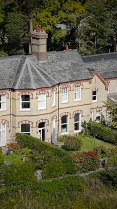 An aerial view of a cream coloured house.