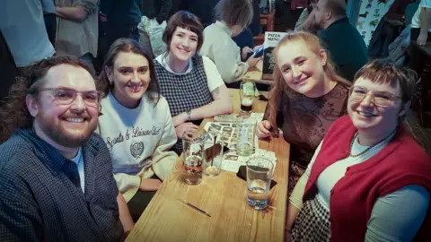 Group of people attending pub quiz