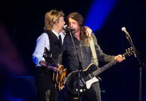 Getty Images Paul McCartney puts his arm around Dave Grohl as they play together on Glastonbury's Pyramid Stage in 2022