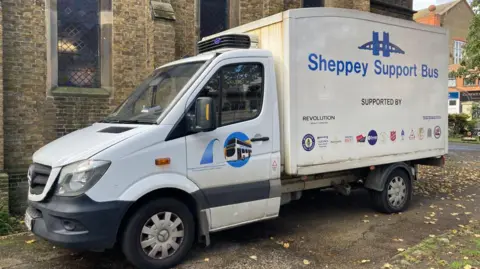 An exterior shot of the Sheppey Support Bus which is a white Mercedes Sprinter van with logos on the side