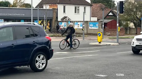 Jozef Hall/BBC A man on a bicycle using the road rather than the junction