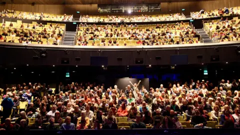 Manchester Film Festival handout Crowds packed into Aviva Studio for the opening night of the Manchester Film Festival in 2025. Almost all the yellow seats are full in the stalls with the audience filling about half of the seats on the balcony.