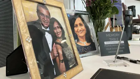  "Memory Table. Please sign and share your thoughts or memories here". Next to it is a black book and three pens.