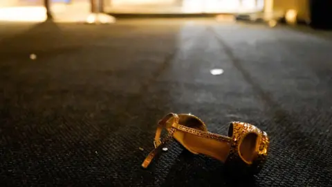 Reuters A woman's dress shoe in gold light lays on carpet