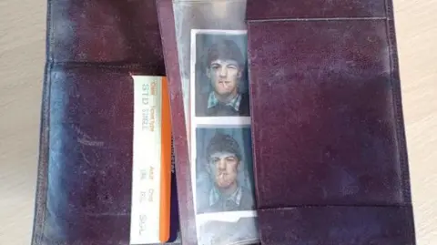 North East Lincolnshire Council A wallet, laid open, with the top half of a single train ticket poking out, and some passport-type photos of a young man posing with a cigarette in his mouth whilst trying to smile at the camera.