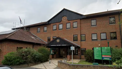 Google A brown tall building with a sign saying Tandridge District Council above the entrance