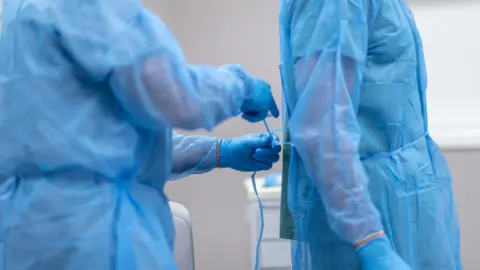 Getty Creative A generic photograph of two surgeons with blue aprons and blue gloves