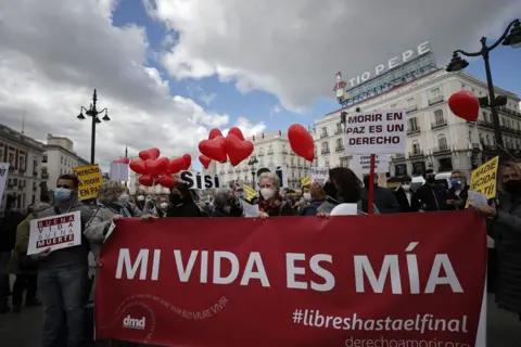 Getty Images A group of people gather to support the law drafted at the initiative of the left coalition government and legalised the euthanasia in Madrid, Spain on March 18, 2021.