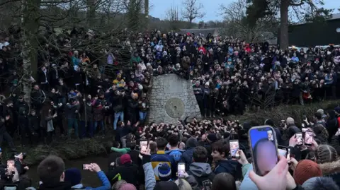 Hundreds of people gather in river as goal is scored in Royal Shrovetide game