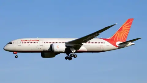 An Air India Boeing 787-8 Dreamliner seen against the blue sky.