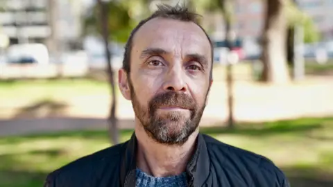BBC/Moose Campbell A man in a beard and short hair wearing a blue jacket looks at the camera